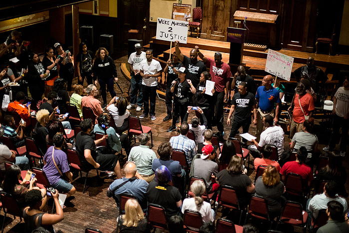 Marchers speak to residents at the National Urban League in Baltimore.