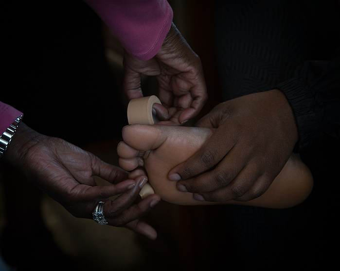 A nurse tapes a marcher's foot before the start of the day's march.