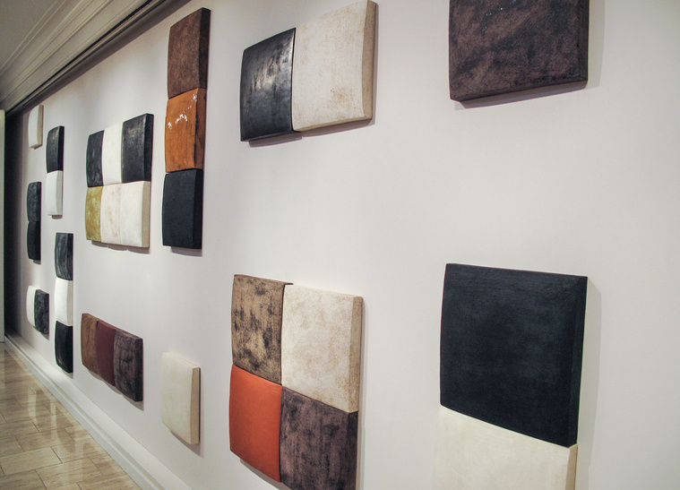 Closeup of Particular Balance is a stoneware wall sculpture by Kathy Erteman arranged in an abstract pattern. This ceramic installation illustrates why the artist is popular with architects and interior designers looking for dynamic art for projects