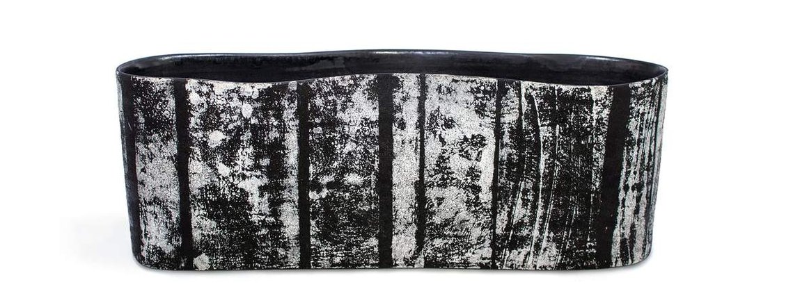 Made of porcelain, Swerve 2 Vessel is a wavy white and black contemporary ceramic vessel with a textural glaze that Kathy Erteman achieved by printing on clay. Her art is available through Hostler Burrows