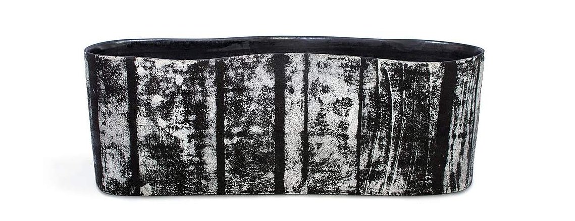 Made of porcelain, Swerve 2 Vessel is a wavy white and black contemporary ceramic vessel with a textural glaze that Kathy Erteman achieved by printing on clay. Her art is available through Hostler Burrows
