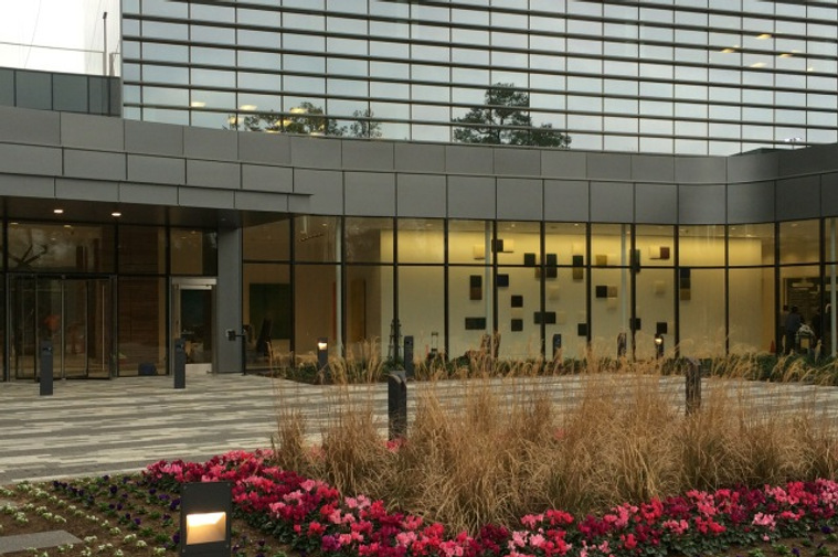 Exterior view of an installation of Kathy Erteman’s ceramic wall squares chosen by Gensler Architects for the SWN Corporate Headquarters. The large-scale architectural wall art is in varying colors of black, white, ochre, and grey textured glazes