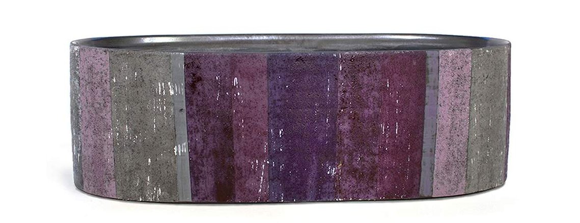 Albers and Indigo Long Vessel by Kathy Erteman is a stoneware  sculptural ceramic piece with stripes of grey to purple. The wheel-thrown altered oval has a texture glaze