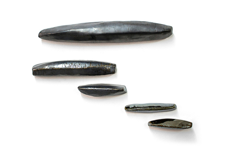 Ledge is a porcelain wall sculpture that illustrates artist Kathy Erteman’s skill with sculpted elements. Mounted horizontally, organic shapes in a pewter glaze that make up the ceramic sculpture seem like natural forms made by nature.  