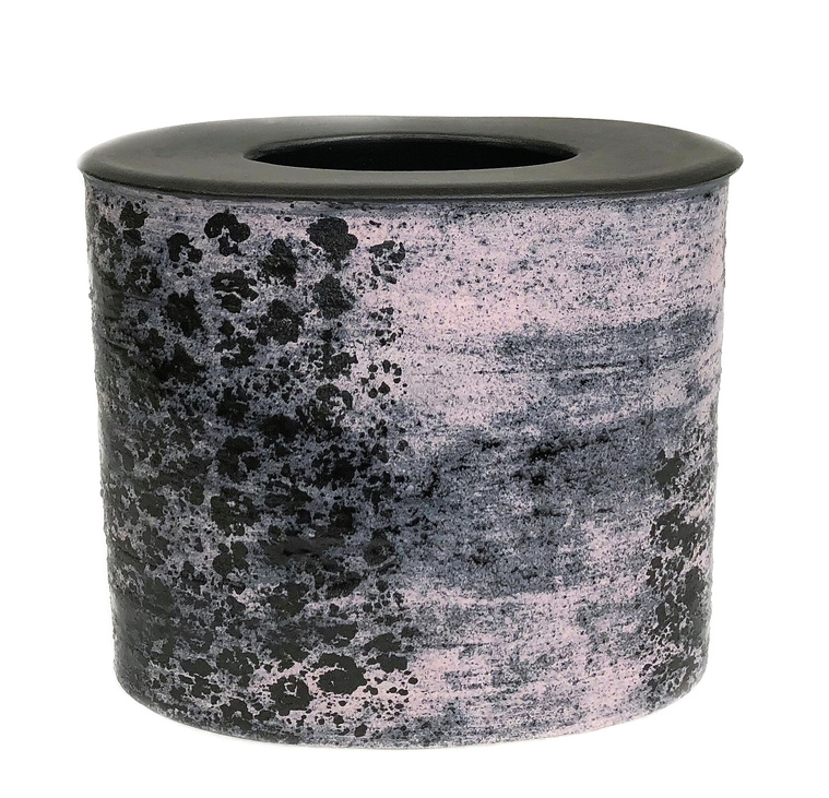 The Pink Dot Vessel by Kathy Erteman is an oval ceramic vessel hand-built from stoneware with a pink and black texture glaze. The dot design on sides and the black closed in top make it function as an artful vase