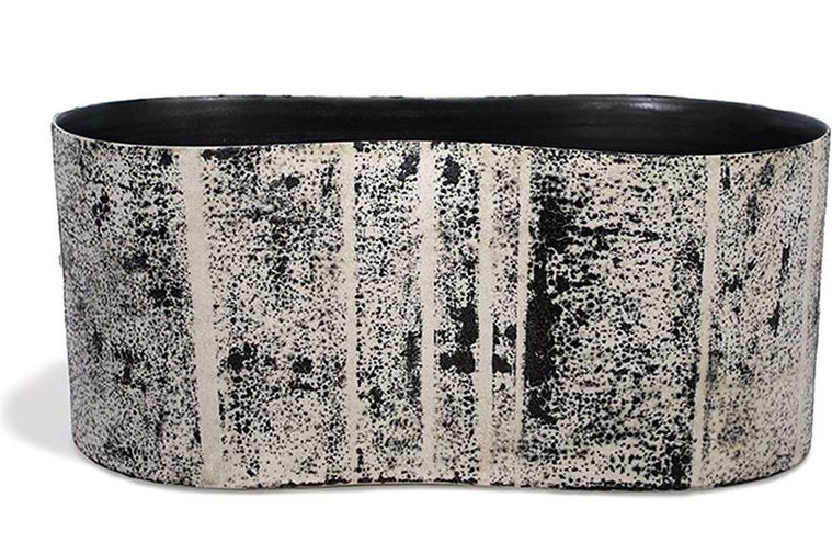 Artist Kathy Erteman created Swerve # 1 Long Vessel, a wheel thrown and altered sculptural ceramic vessel with a white texture glaze and mono-printed black exterior with a black glazed interior for a modernist feel
