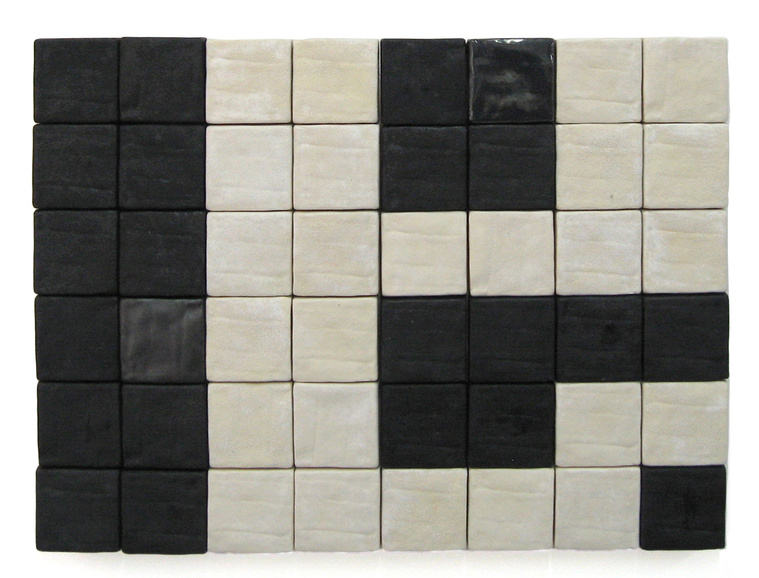 Arial View is a black and white wall composition made of two-inch ceramic wall squares. Artist Kathy Erteman created the slip cast architectural installation and gave them a textured glaze. The custom-made ceramic wall art is mounted on wood panels