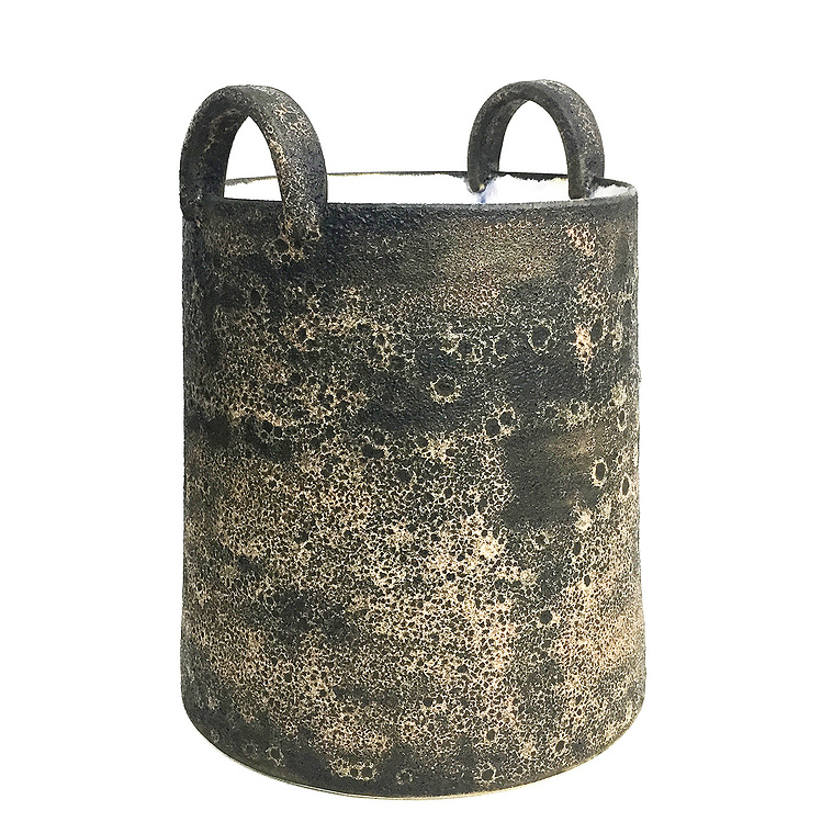 The Lava Handles Vessel by Kathy Erteman is a wheel thrown vessel with tiny handles and a lava texture glaze in brown with white and pink tones. The gloss white glaze interior contemporizes this ceramic piece inspired by a bucket