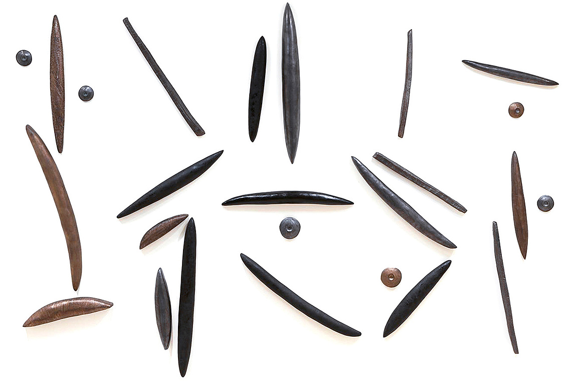Catalpa Seeds & Pods is a stoneware wall installation hand-built and sculpted by artist Kathy Erteman. The wall-mounted abstract ceramic shapes that make up the architectural installation range from bronze, pewter and black hues