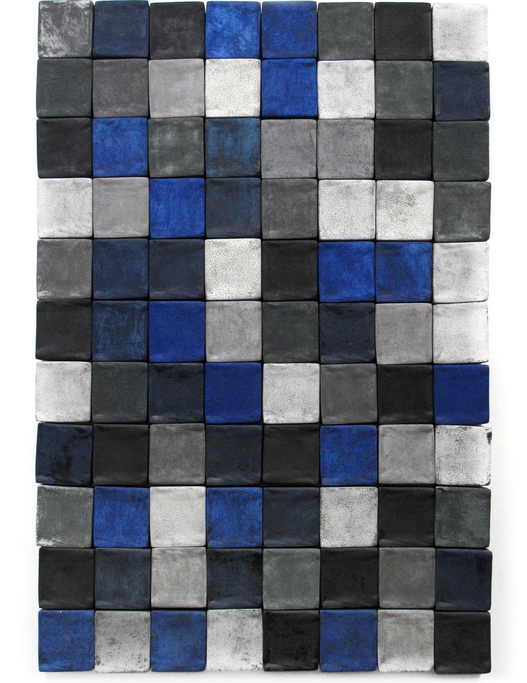 Slip-cast four-inch ceramic wall squares in Yves Klein blue, grey, charcoal, and white are arranged in aflush design to create this wall art titled Indigo Flush. The architectural installation was created by Hudson Valley artist Kathy Erteman.