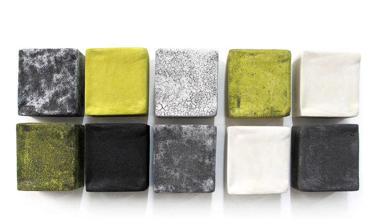 Yolk, an architectural installation by artist Kathy Erteman, is made up of four-inch ceramic wall squares in various yellows complemented by black and white squares in a textured glaze. The decorative wall piece was commissioned by an art collector.