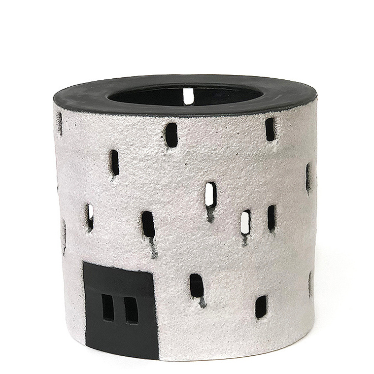 This oval ceramic vessel is titled Tulou Vessel 1. Hand-built of stoneware in strips by artist Kathy Erteman, it was inspired by Tulou architecture. The windows on the black and white vessel with the textured white glaze are pierced cutouts