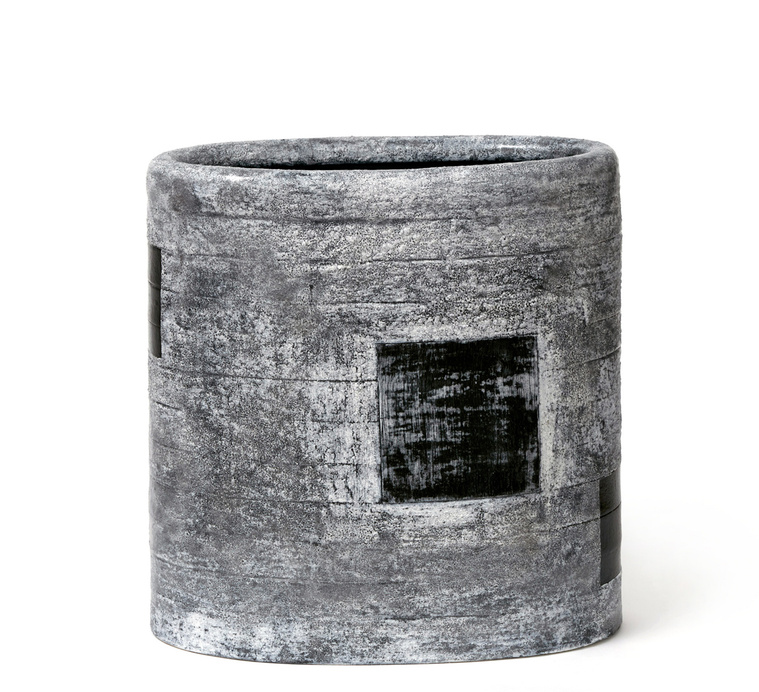 Kathy Erteman, a New York City artist, created Black Window Vessel, which she hand-built with strips. The ceramic vessel with a black and white textural surface has black inset squares and a moody crusty glaze