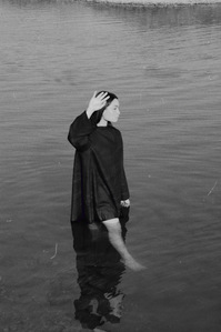 sun in eyes hand to block black and white Sacramento lake model moody walking through water