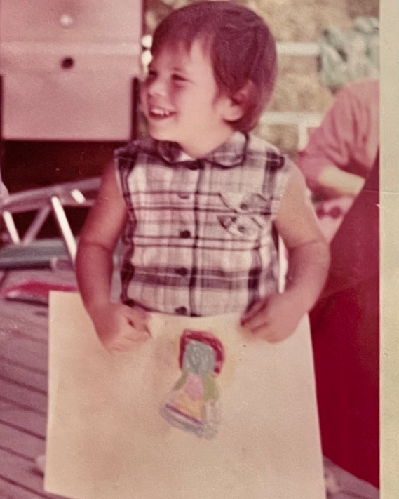 LK Glickman as a very young child holding up her artwork