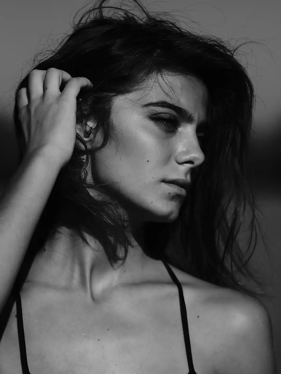 Black and white portrait of a woman with dramatic lighting, captured in a minimalist style.