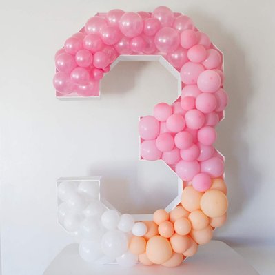 In front of a white wall is a balloon mosaic number three of pink and white balloons