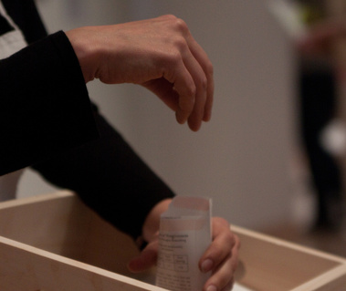 photographs from douglas rosenberg's relational performance art work forgiveness, showing white envelopes from the performance being filled with hyacinth seeds by participants in the gallery