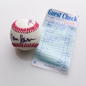 photograph of ephemera from douglas rosenberg's relational performance, containing a baseball signed by all participants in the performance and the bill for the breakfast