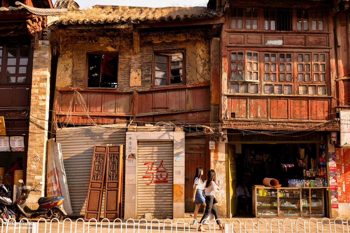 Two young women walking past an historic building in Old Town Kunming in China. 