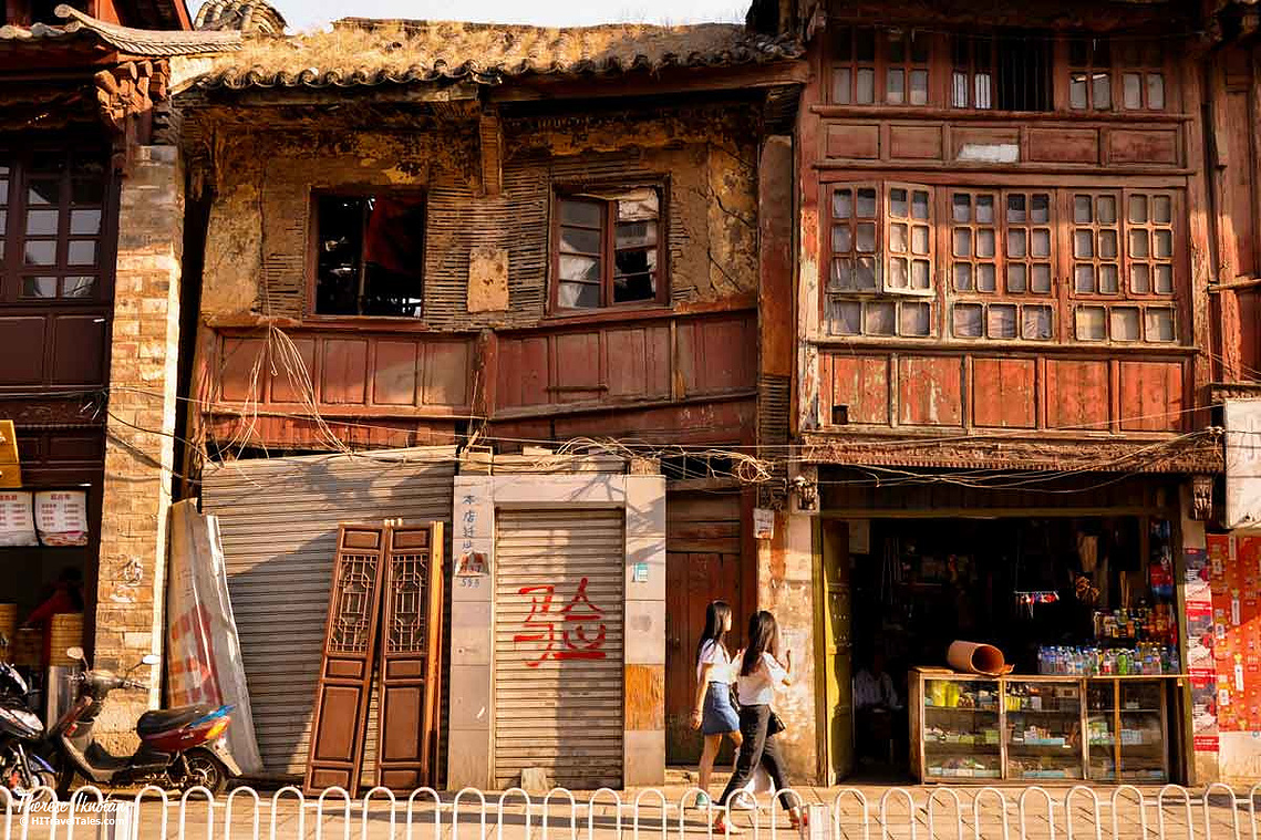 Two young women walking past an historic building in Old Town Kunming in China. 