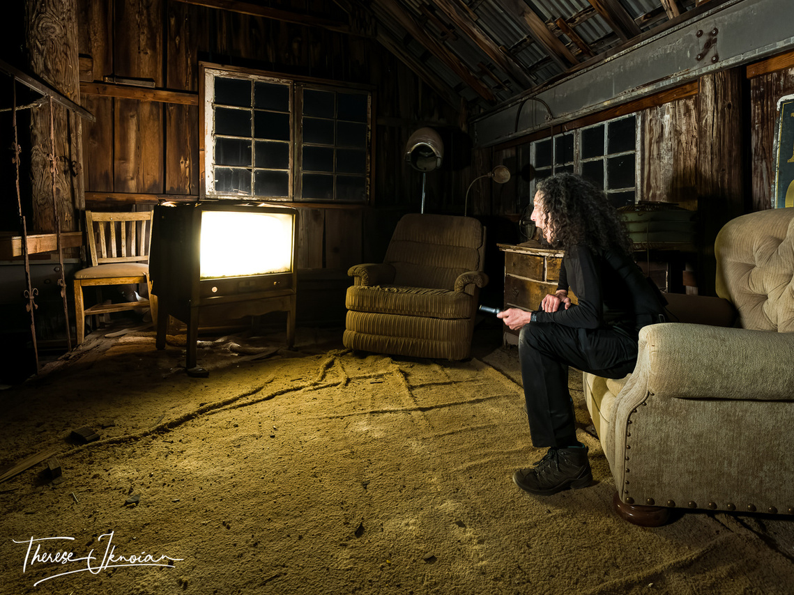 The photographer places herself in a light-painted scene inside an old barn at Nelson Ghost Town in Nevada for an eerie effect. 