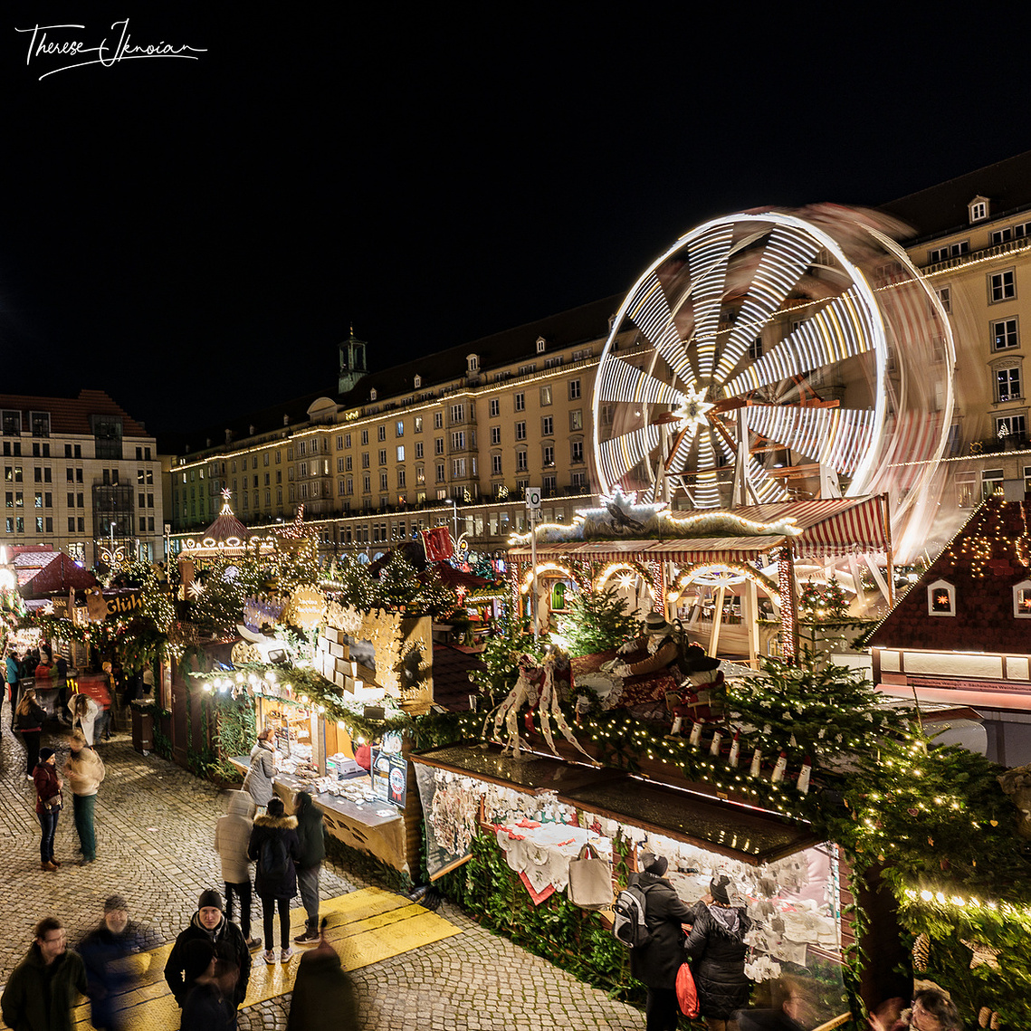 Night photo of the famous Dresden Striezelmarkt (Christmas market) with the Ferris Wheel motion blurred. 