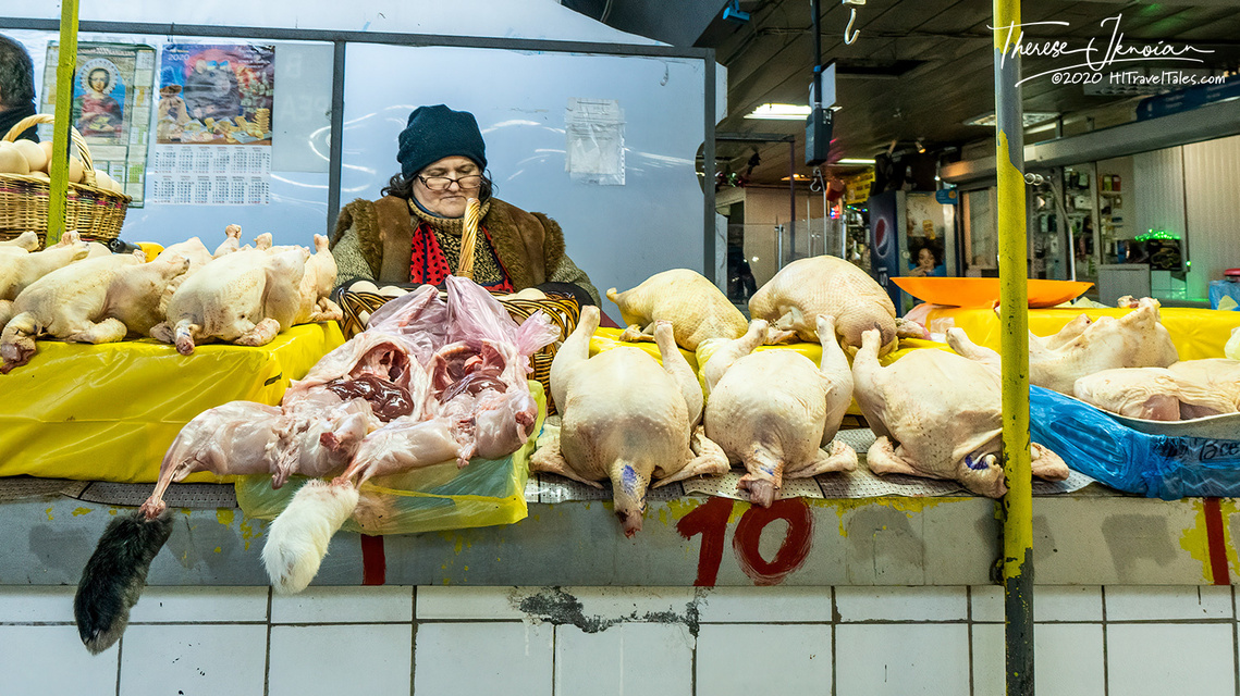 A woman in Kyiv, Ukraine, behind a meat counter selling poultry. 