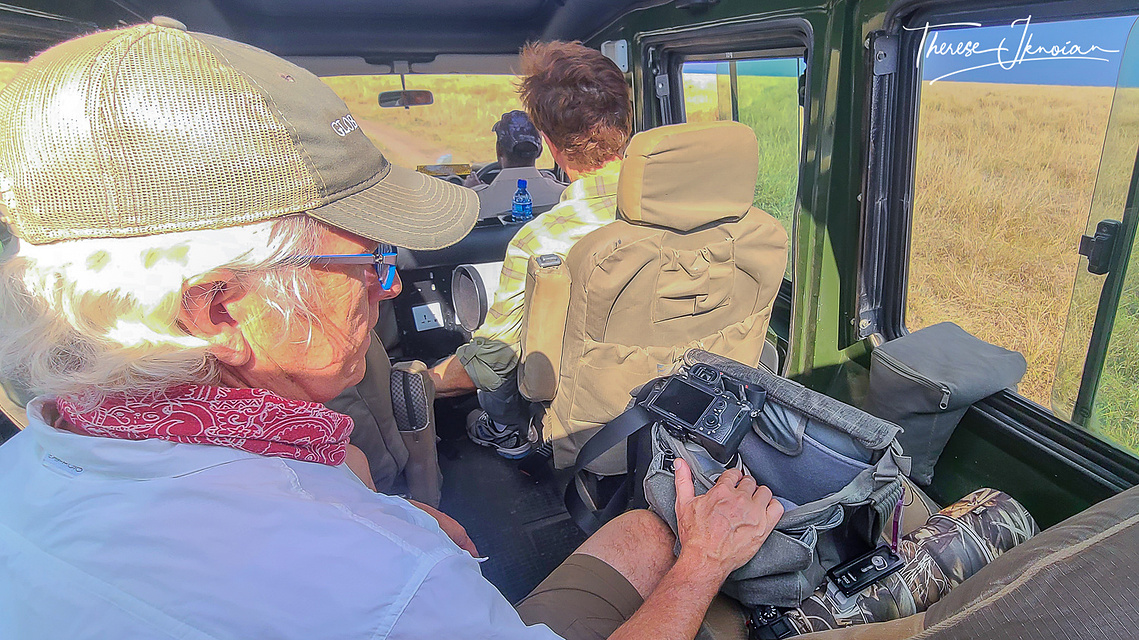Photo of Michael Hodgson with his camera gear beside him inside a safari vehicle on a photo safari in Kenya. 