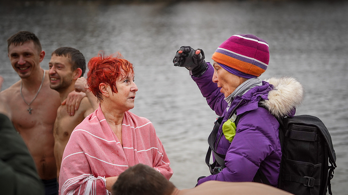 Therese Iknoian interviewing and photographing Ukrainians who had just taken part in a swim in an icy river in January. 