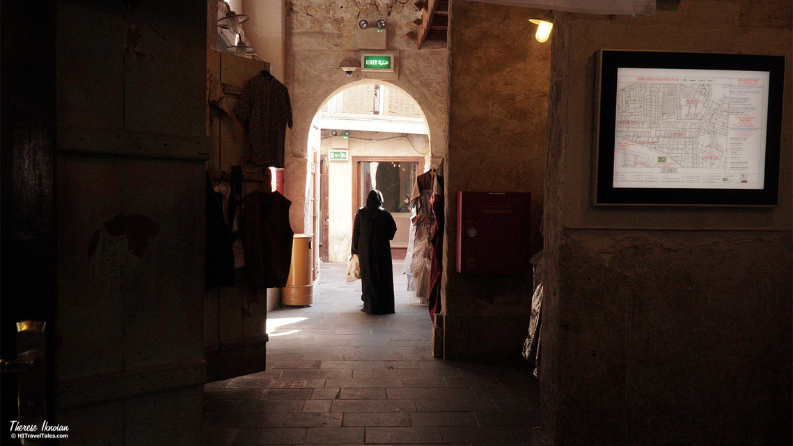 Photo of a woman passing through an arch in the souk in Doha, Qatar -- before photo processing. 