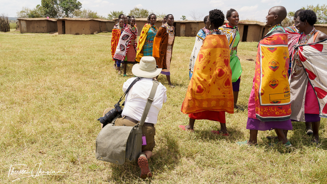 Photo of Michael Hodgson taking photos of Maasai women performing a dance in a Maasai village in Kenya. 