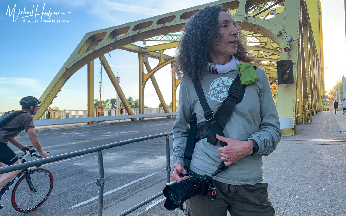 Photographer demonstrating how to shoot from the hip to take a photo on the sly. 
