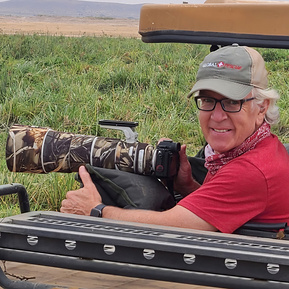 Michael Hodgson, photographer, in a safari vehicle with his camera in Kenya.