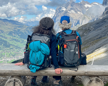 Michael Hodgson and Therese Iknoian sitting on a bench in the Alps of Switzerland.