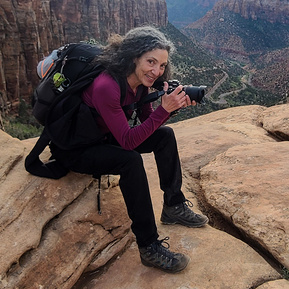 Therese Iknoian, photographer, sitting at the edge of a canyon wall in Utah