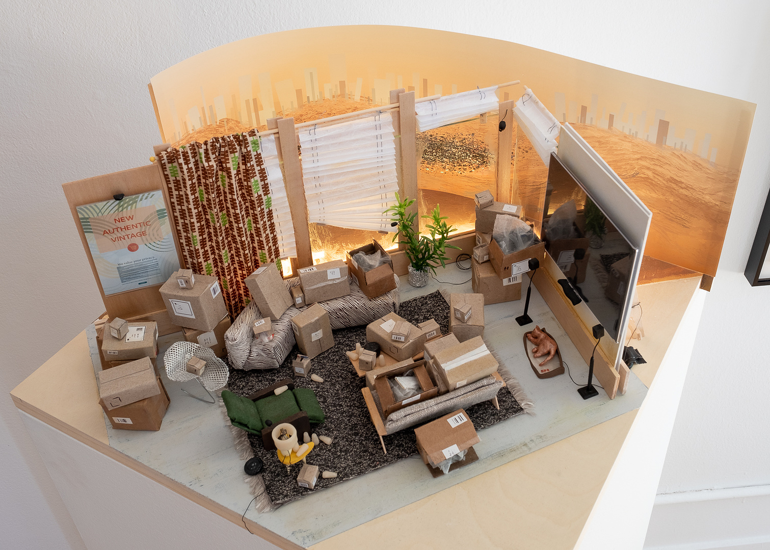 Sculpture, model of a living room full of cardboard boxes and multiple screens