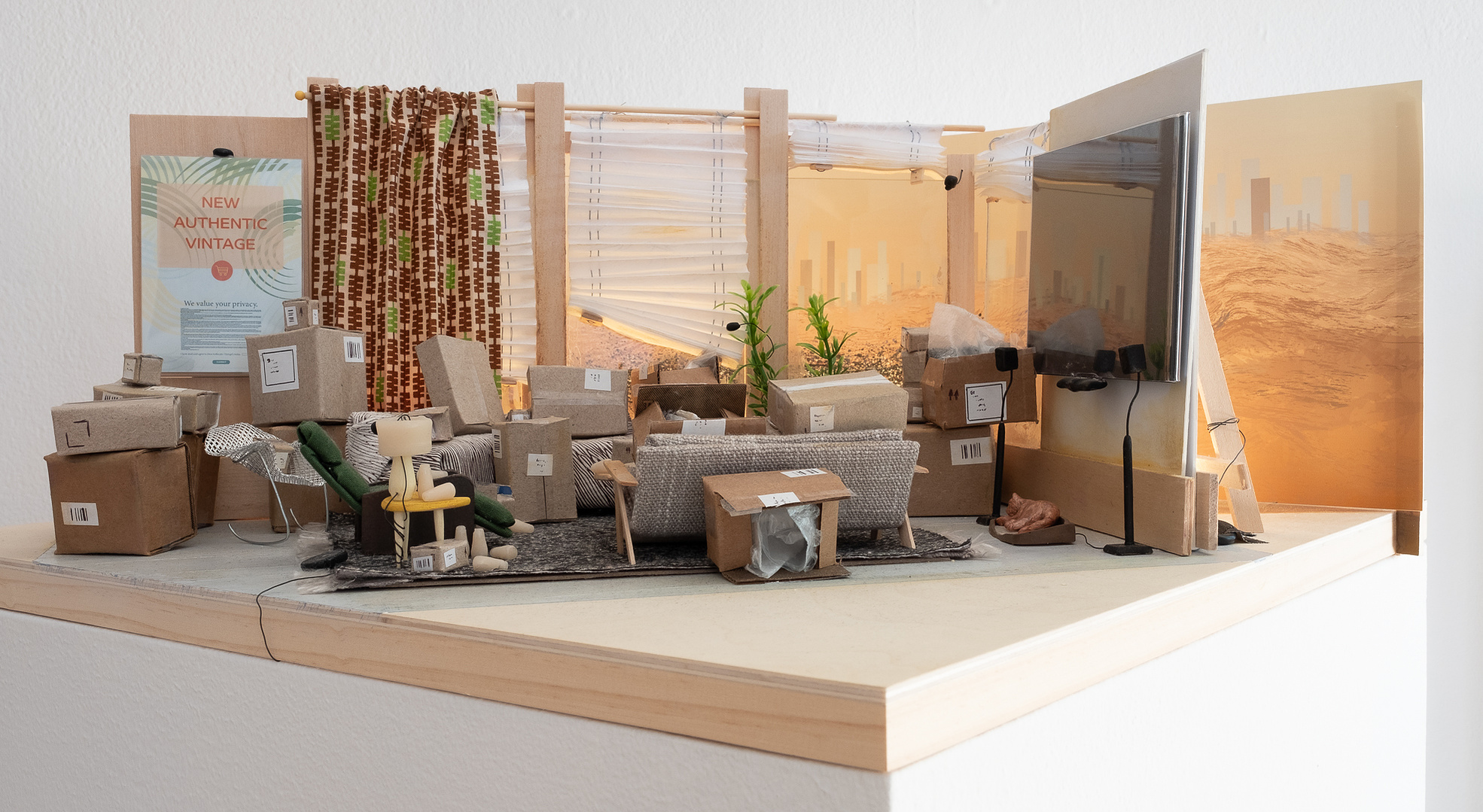 Sculpture, model of a living room full of cardboard boxes and multiple screens
