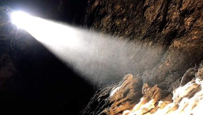 Sunlight beams through an opening in a cave in the Mojave desert.