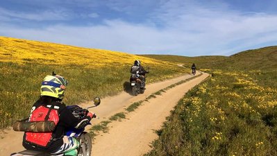 Dirt bikers roar down a dirt road in California's Carrizo Plain.