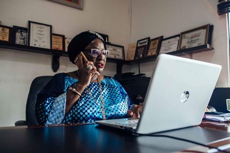 Moji Makanjuola uses her phone whilst working at her office in Garki, Abuja, Nigeria on Wednesday 16 December 2020. KC Nwakalor for Global Citizen.