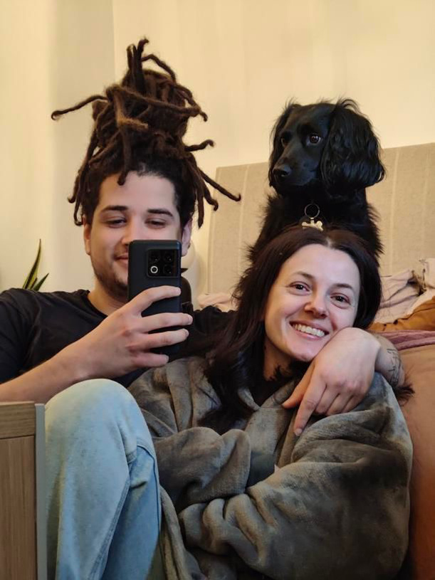 Portrait reference photo for Artist Mary Naylor. A couple smiling for a selfie in the mirror with their dog.