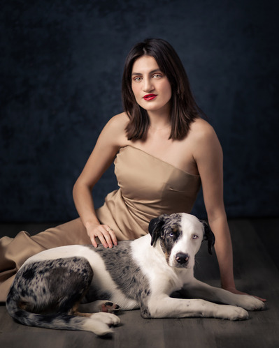 Painterly portrait of a lady and her dog both sitting on the floor in the studio