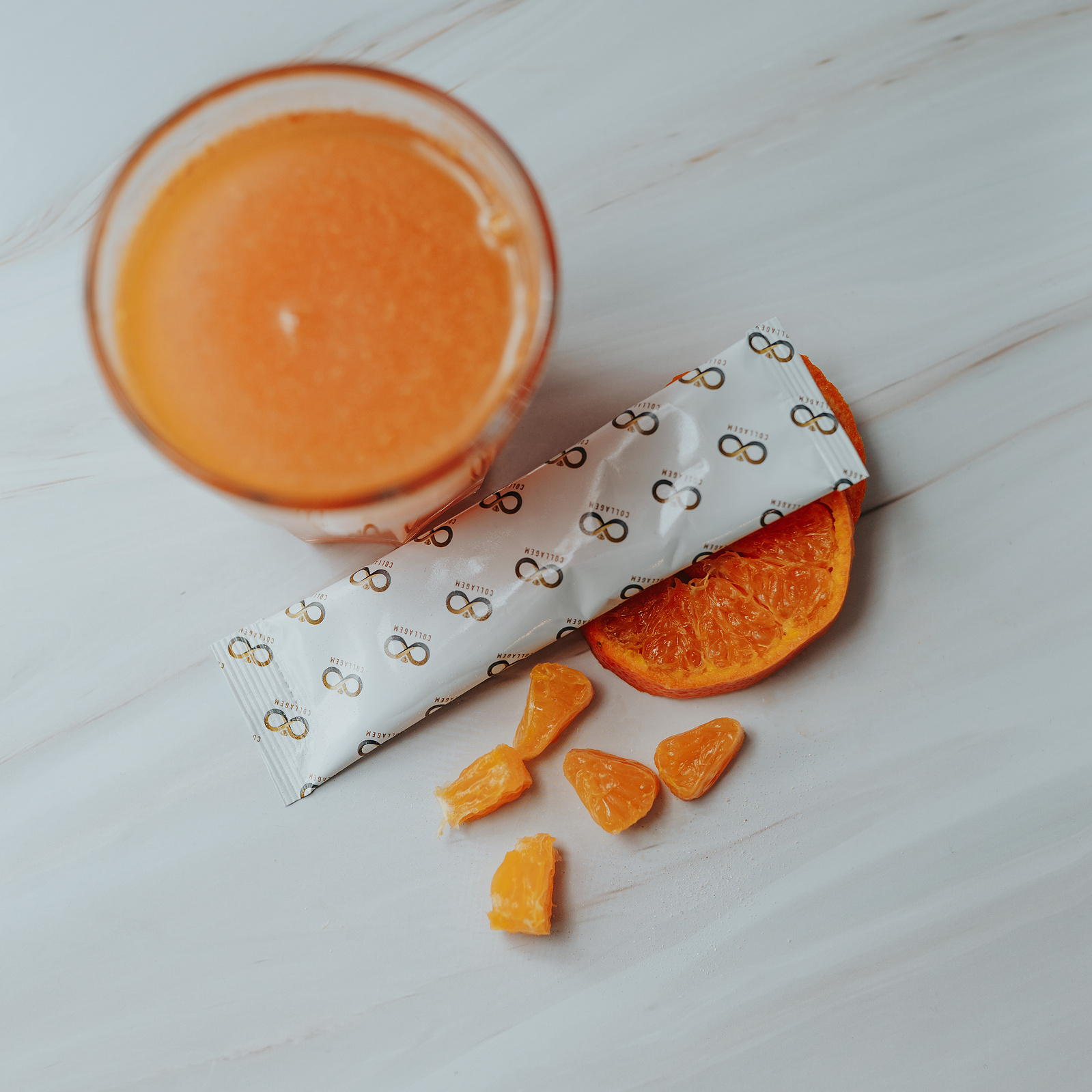 Product photography. Collagem sachet in a glass of water. Sliced nectarines decorate the image.
