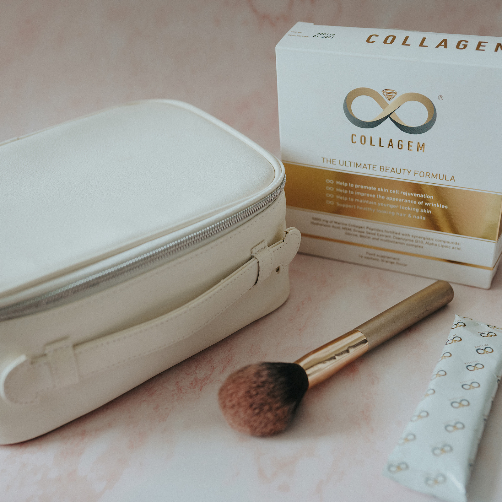 Product photography. Collagem sachet and box amongst makeup and skincare products.