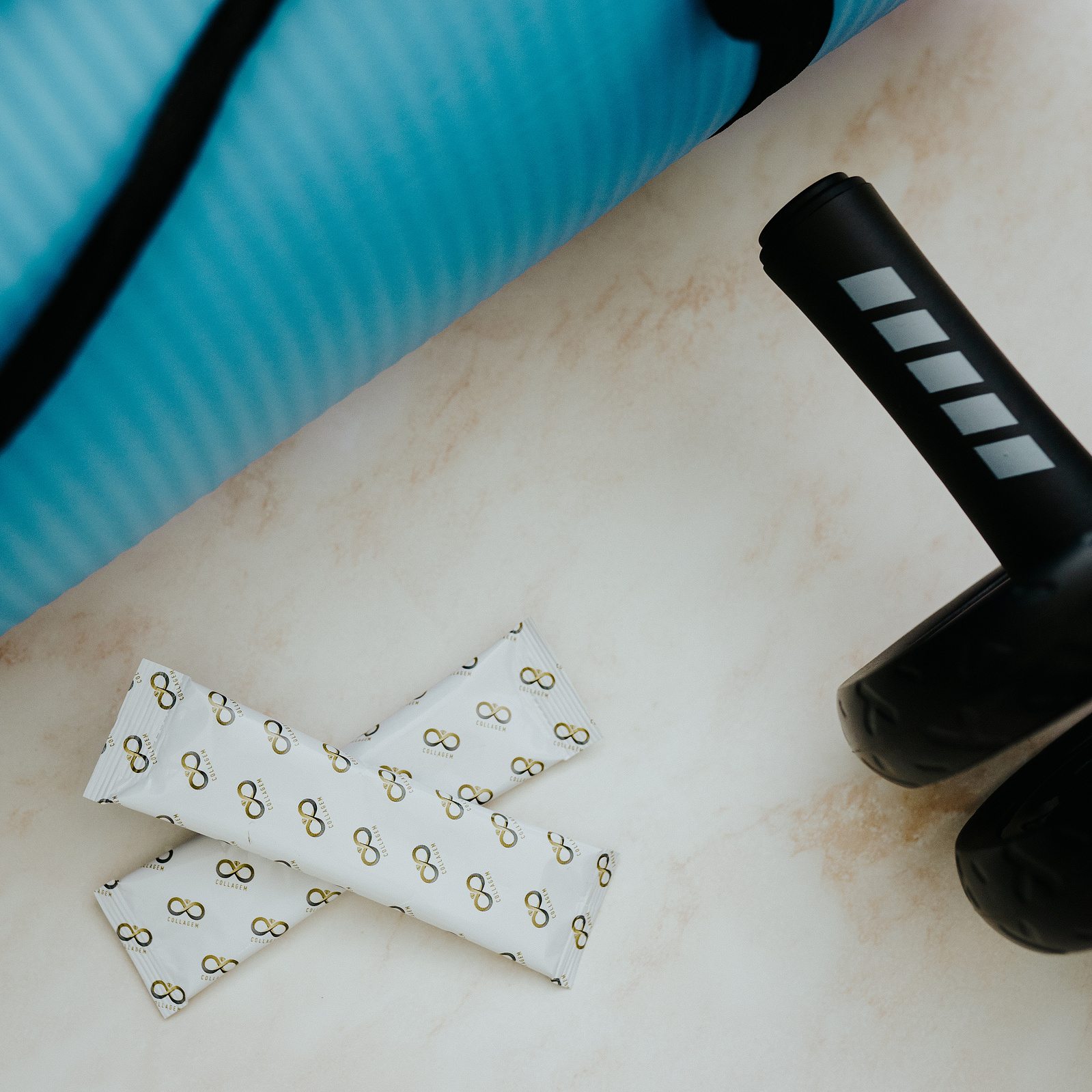 Product photography. Collagem sachet amongst gym equipment.