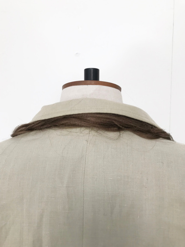 Integrating hair with garments. Fake hair on the collar of a beige men's jacket.