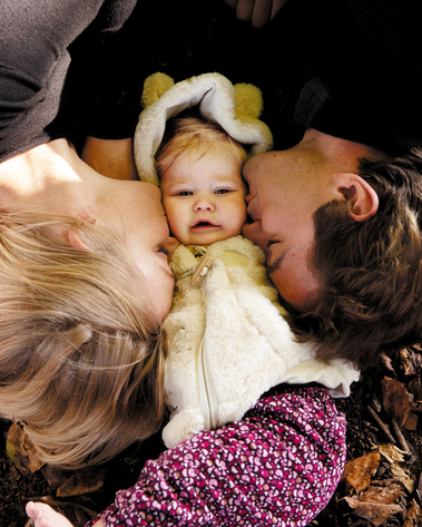 Family photography. A young couple have their portrait taken with their baby daughter and  express their appreciation and thanks.