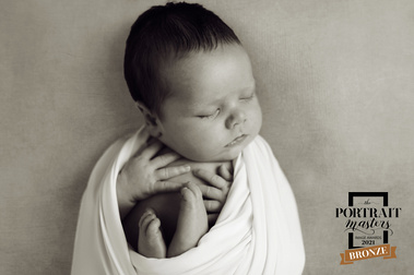 Portrait Masters Bronze Image award for this black and white photo of this wrapped newborn baby. Shot in Geneva by Helen Putsman, portrait photographer.