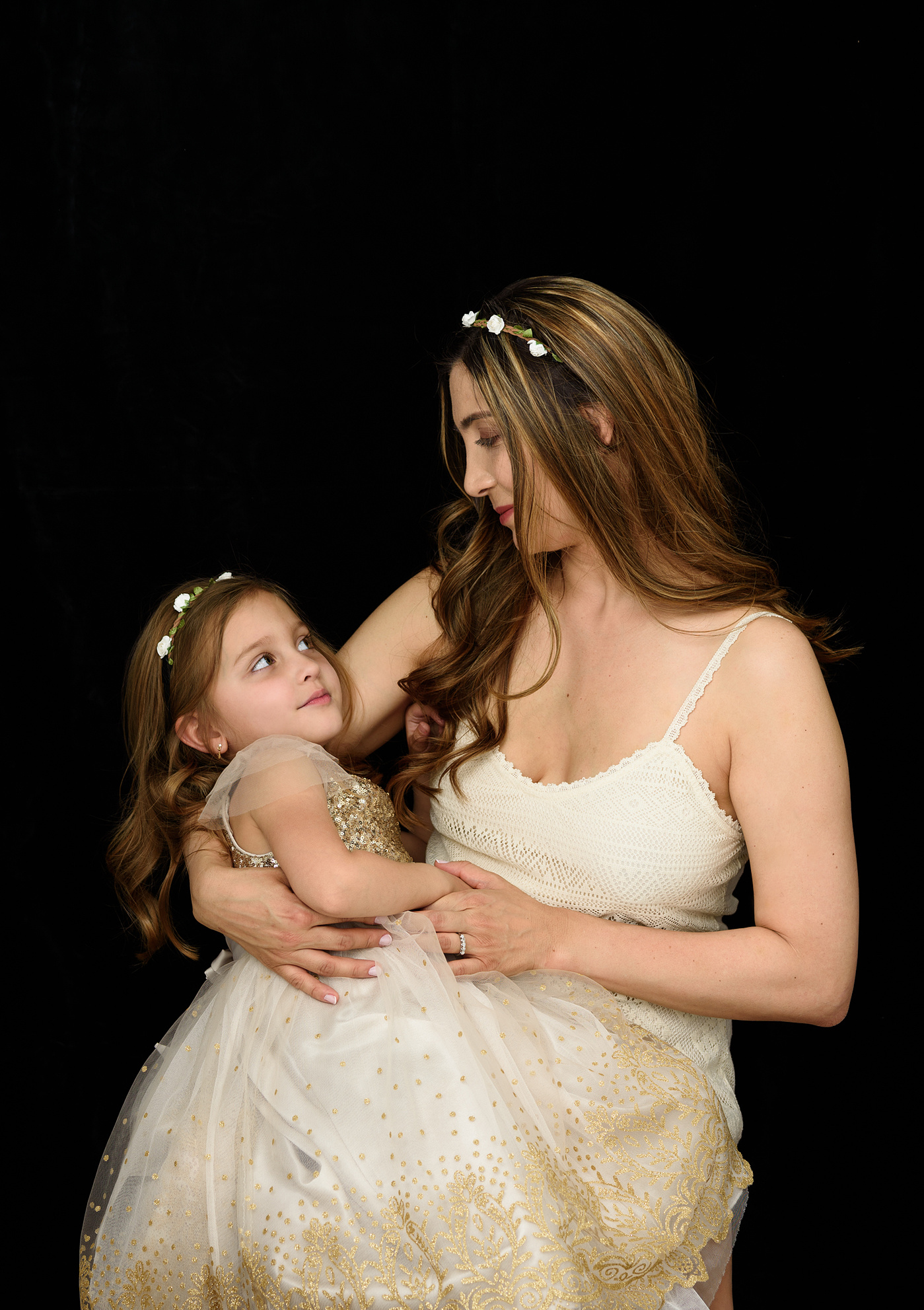 Fine-art Mummy and Me portrait. Mother photographed with her daughter, both wearing cream coloured dresses and flowered headbands. We created Mummy and Me portraits to treasure as Wall Art to remind the family everyday of their love for each other.
